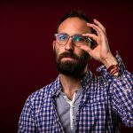 man in blue and white plaid button up shirt wearing black framed eyeglasses