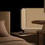 Une lampe LED élégante mise en scène dans un intérieur minimaliste, entre chambre et espace de travail. L’image illustre un éclairage sobre, confortable et polyvalent pour le quotidien.
