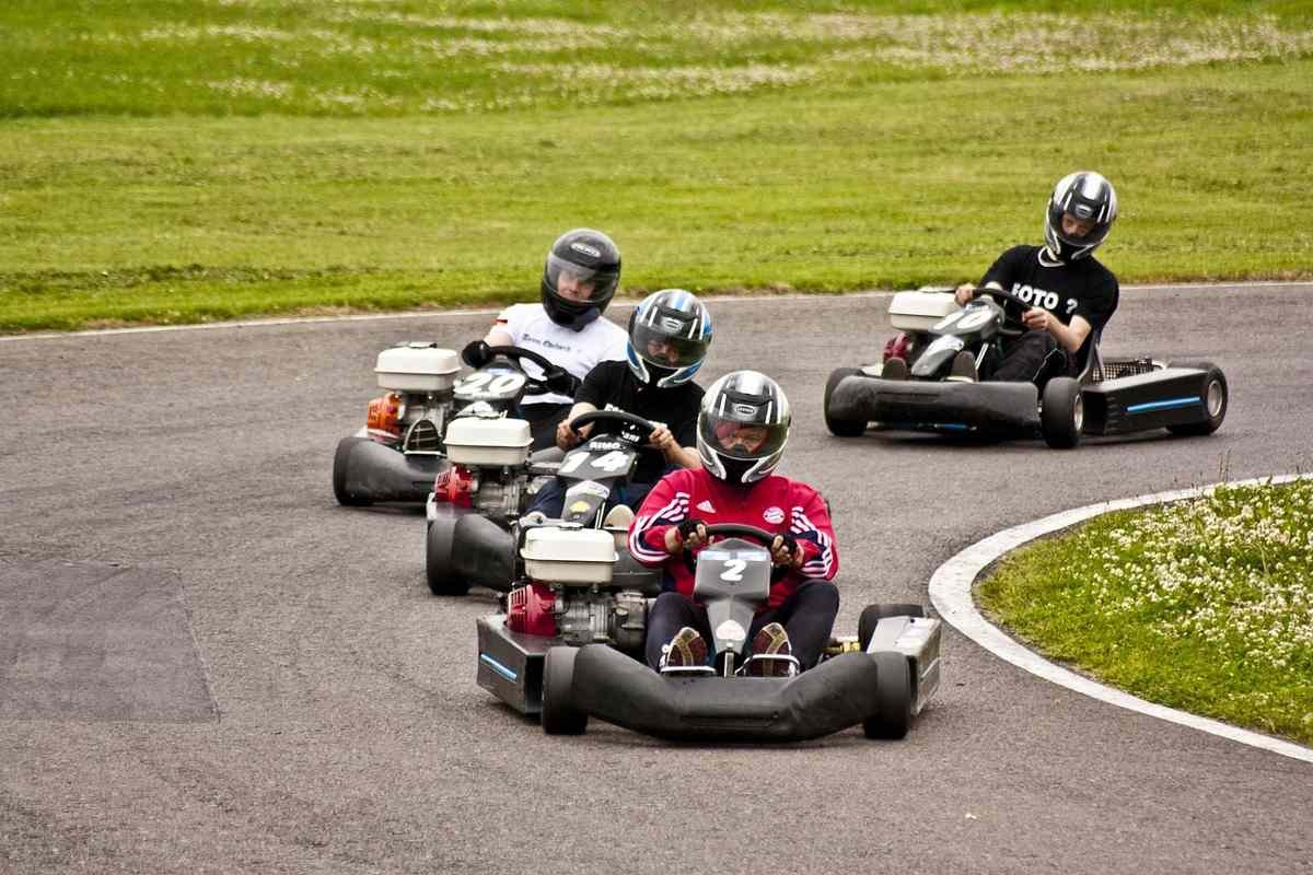 Quatre conducteurs en karting naviguent un virage du circuit Quatre conducteurs en karting naviguent un virage du circuit